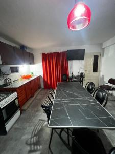 a kitchen with a table and a red curtain at Casita de los recuerdos in Villa Carlos Paz +4 photos