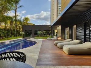 una casa con piscina y tumbonas en Caesar Business Belo Horizonte Belvedere, en Belo Horizonte