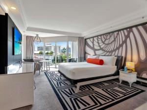 a bedroom with a bed and a living room at Pullman Cairns International in Cairns