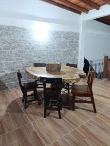 a table and chairs in a room with a brick wall at Colonial Hostal Filandia in El Pueblo