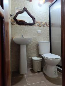 a bathroom with a toilet and a sink and a mirror at Colonial Hostal Filandia in El Pueblo +10 photos