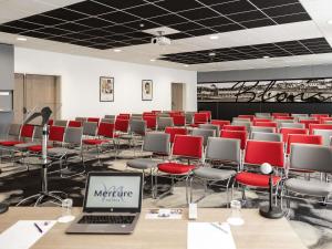 a conference room with red chairs and a laptop on a table at Hotel Mercure Blois Centre in Blois +88 photos