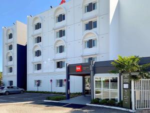 Un edificio blanco con un cartel delante. en ibis Bordeaux Pessac Route des Vins, en Pessac