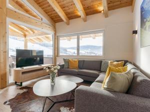 a living room with a couch and a tv at Grebenzen Lodge Pabstin 36B in Sankt Lambrecht