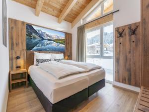 a bedroom with a large bed and a large window at Grebenzen Lodge Pabstin 36B in Sankt Lambrecht