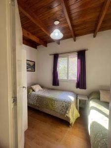 a bedroom with two beds and a window at Cabaña Paz in Capilla del Monte