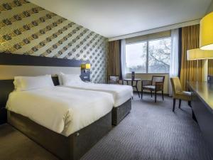 a hotel room with a large bed and a desk at Mercure Antwerp City South in Antwerp