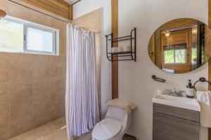 ein Badezimmer mit Toilette, Waschbecken und Spiegel in der Unterkunft Tekio Beach Hotel in Holbox