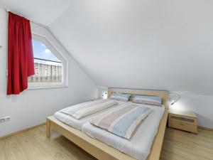 a bedroom with a bed with a red window at Stranddistel links mit Sauna in Boiensdorf