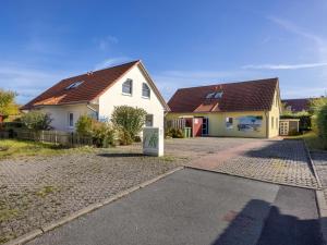 a white house with a brown roof and a driveway at Stranddistel links mit Sauna in Boiensdorf