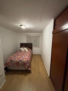 a small bedroom with a bed and a closet at Amplia Casa en Viña del Mar in Viña del Mar +5 photos