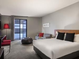 a hotel room with a bed and a living room at Mantra Hindmarsh Square in Adelaide +49 photos