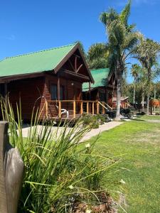 a house with a green roof and a palm tree at Miraflores Relax & Pool in Miramar
