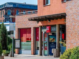 a brick building with a sign in front of it at Ibis Katowice - Zabrze in Zabrze