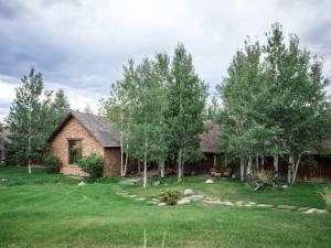 a house with a yard and trees in front of it at 104-Acre Private Ranch Retreat in Paradise Valley Montana in White City