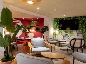 a waiting room with chairs and tables and plants at ibis Beziers Est Mediterranee A9/A75 in Béziers