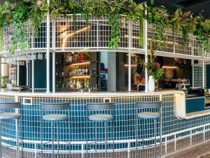 eine Bar mit Stühlen und Pflanzen darüber in der Unterkunft ibis Medellin in Medellín