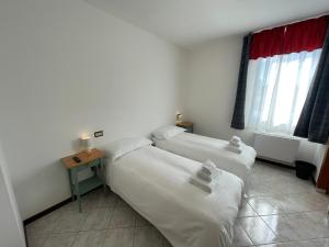 a room with two beds and a table with a window at Albergaria 