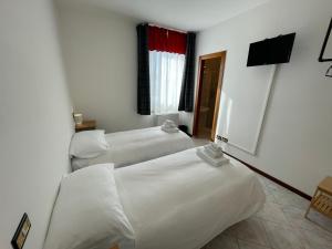 a hotel room with two beds and a television at Albergaria  +23 photos