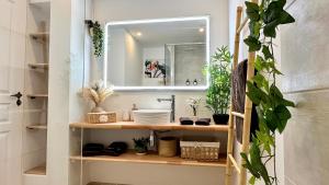 a bathroom with a sink and a mirror and plants at Grenade 21 vue mer proche plage dans Complexe type Village Vacances in Sainte-Luce +33 photos
