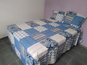 Una cama con un edredón azul y blanco. en Casa Aconchegante em Miguel Pereira, en Miguel Pereira
