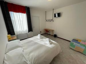 a bedroom with a white bed and a table at Albergaria 