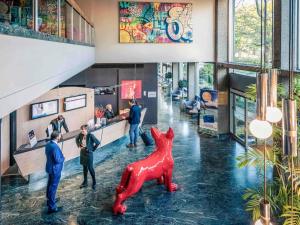 a lobby with a red dog statue in the middle at Mercure Mulhouse Centre in Mulhouse