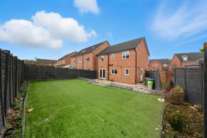 a backyard with a large lawn in front of a house at Lara's 4 Bedroom House near Coventry in Coventry