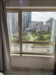 a window with a view of a city at Luxury 3-Bedroom Apartment with Garden View opposite to Safiya Park in Sharjah