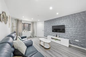 a living room with a couch and a tv at Lara's 4 Bedroom House near Coventry in Coventry
