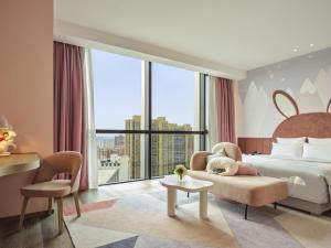 1 dormitorio con cama, silla y ventana grande en Novotel Shanghai Qingpu Excellence, en Shanghái 70 fotos más