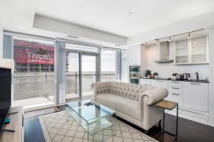 a living room with a couch and a glass table at Luxury 1BR Suite - Lake & City View on 39th Floor in Toronto