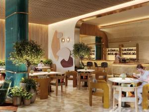a restaurant with tables and people sitting at them at Pullman Resort Al Marjan Island in Ras al Khaimah