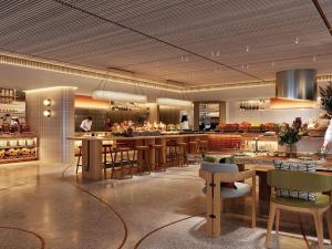 a restaurant with tables and chairs in a kitchen at Pullman Resort Al Marjan Island in Ras al Khaimah