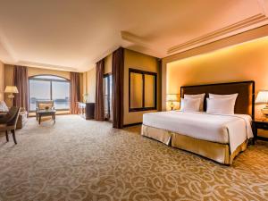 a hotel room with a large bed and a desk at Pullman Resort Al Marjan Island in Ras al Khaimah