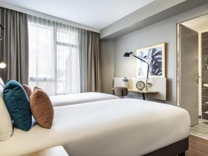 Ένα ή περισσότερα κρεβάτια σε δωμάτιο στο Aparthotel Adagio Paris Suresnes Longchamp