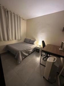 a bedroom with a bed and a desk and a desk at Quarto com banheiro privativo em Belo Horizonte - MG in Belo Horizonte