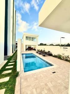 a swimming pool in the backyard of a house at Alma Ivet III 5min From The Airport & Boca Chica Beach in Monte Adentro
