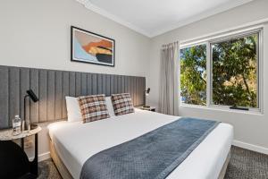 Un dormitorio con una cama grande y una ventana. en Quest Campbelltown, en Campbelltown 26 fotos más