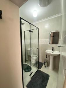 a bathroom with a glass shower and a sink at The Cosy Retreat Guest House in Gaborone +6 photos