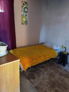 1 dormitorio con 1 cama con manta amarilla en Casas de passed, en Balneario Buenos Aires
