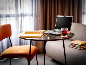 a table with a laptop and a book and glasses on it at Novotel SP Jardins in Sao Paulo +134 photos