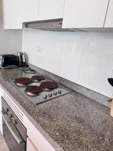 QuinquimoにあるDepartamento Papudo lagunaのチョコレートケーキが載ったコンロのあるキッチン