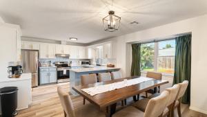 a kitchen and dining room with a wooden table and chairs at Luxury 3 Bdr Edmond, Fuseball, Pac-man, Sleeps 9 in Edmond