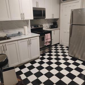 a kitchen with a black and white checkered floor at THE BLOOR AC SUITE-Free Wifi-Train-Bus Stop Next Door in Toronto