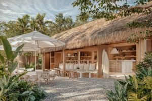 サンタ・テレサにあるHotel Fermataの茅葺き屋根とサーフボードのあるリゾート