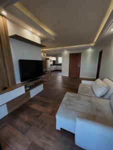 a living room with a flat screen tv and a couch at Refúgio Vista Mar Balneário Piçarras in Piçarras