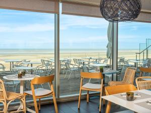 a restaurant with tables and chairs and a view of the beach at ibis Thalassa Le Touquet in Le Touquet-Paris-Plage