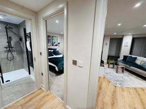 a living room with a mirror and a bedroom at Central Leeds Apartment by the Arena with on-site parking in Leeds +19 photos