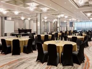 a conference room with tables and chairs and a screen at Mercure Samarinda in Samarinda +105 photos